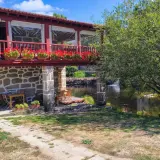 Casa rural con balcón florido y río. Un lugar idílico para descubrir qué ver en Allariz y disfrutar de la naturaleza.