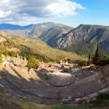 Teatro antiguo en Delfos, Grecia. Un lugar imprescindible que ver en Grecia en una semana, con vistas a montañas y ruinas.