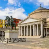 Plaza con estatua ecuestre y el Palacio Real de Nápoles, ideal para un free tour Nápoles.