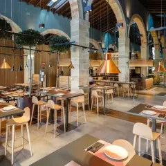 Mesas listas para comer en el puerto de Santa María. Ambiente moderno con lámparas de cobre y detalles de madera.