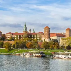 Castillo de Wawel sobre el río Vístula, ideal para excursiones en Krakow. Barcos turísticos esperan a los visitantes.