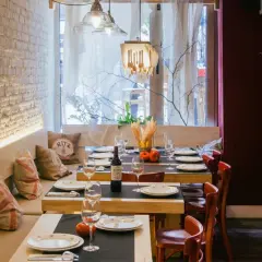 Mesas puestas en un restaurante acogedor, ideal para saber donde comer en Santander. Ambiente rústico con detalles de madera y ladrillo.