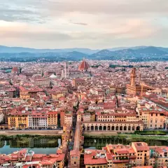 Vista panorámica de Florencia al atardecer, con la cúpula del Duomo y el Ponte Vecchio. Ideal para un **free tour Florencia**.
