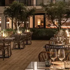 Terraza de restaurante con mesas puestas y luces tenues, ideal para saber donde comer en Benidorm.