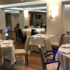 Mesas elegantemente puestas en un restaurante, ideal para saber donde comer en Viveiro.