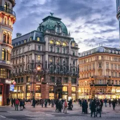 Gente paseando por una plaza en Viena, con edificios históricos y modernos. Ideal para un **free tour Viena**.