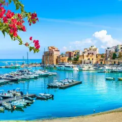 Un puerto vibrante con barcos y casas coloridas, ideal para tu plan de "Sicilia en 7 días".