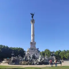 Monumento de la Gironda en Burdeos, ideal para un free tour Burdeos. Gente paseando bajo el cielo azul.