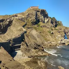Escaleras de piedra ascienden a una ermita en la cima de un acantilado rocoso. Un lugar imprescindible que ver en Bermeo.