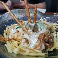 Un plato con patatas fritas, carne y palitos de pretzel. ¡Una idea de dónde comer en Cádiz!