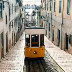 Tranvía amarillo subiendo una calle empedrada en Lisboa. ¡Imprescindible que ver en Lisboa en 4 días!