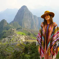 Mujer con poncho colorido y sombrero en Machu Picchu, una experiencia inolvidable al viajar a Perú.