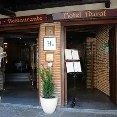 Entrada a Cafetería-Restaurante y Hotel Rural. Un cartel de un camarero invita a descubrir dónde comer en Guadalupe.