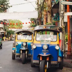 Tuk-tuks coloridos en una calle de Bangkok, perfectos para explorar la ciudad. ¡La mejor época para viajar a Tailandia es ahora!