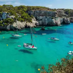 Calas turquesas y veleros anclados, ideal para saber qué ver en Menorca en 3 días. Disfruta de un día perfecto en este paraíso.