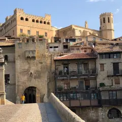 Un hombre cruza el puente hacia el castillo de Valderrobres, un lugar que ver para disfrutar de su arquitectura medieval y sus calles empedradas.