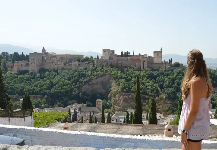 Una mujer contempla la Alhambra, un lugar imprescindible que ver en Granada en 3 días.