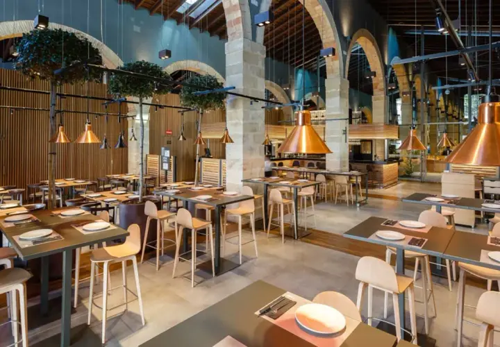 Mesas listas para comer en el puerto de Santa María. Ambiente moderno con lámparas de cobre y detalles de madera.