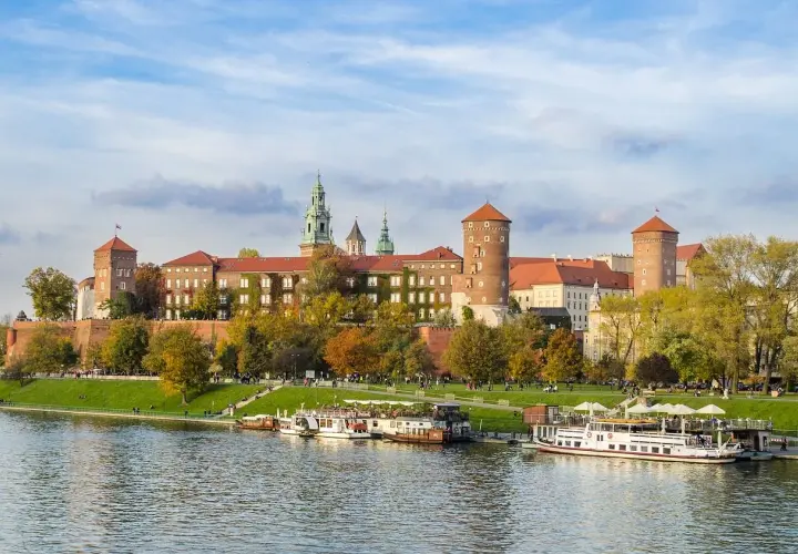 Castillo de Wawel sobre el río Vístula, ideal para excursiones en Krakow. Barcos turísticos esperan a los visitantes.