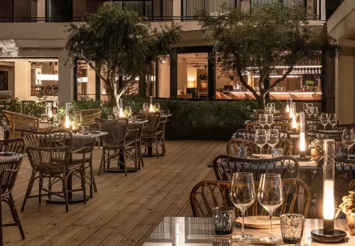 Terraza de restaurante con mesas puestas y luces tenues, ideal para saber donde comer en Benidorm.