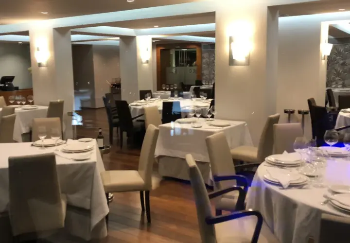 Mesas elegantemente puestas en un restaurante, ideal para saber donde comer en Viveiro.