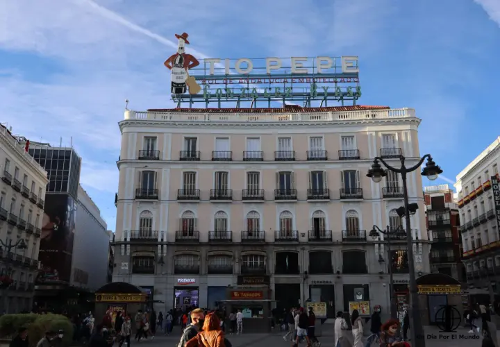 Edificio emblemático en la Puerta del Sol, Madrid. Ideal para saber qué ver en Madrid en un día, con el cartel de Tío Pepe y gente paseando.