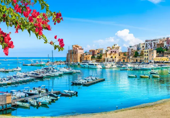 Un puerto vibrante con barcos y casas coloridas, ideal para tu plan de "Sicilia en 7 días".