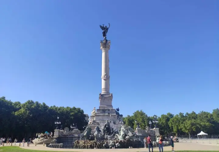 Monumento de la Gironda en Burdeos, ideal para un free tour Burdeos. Gente paseando bajo el cielo azul.