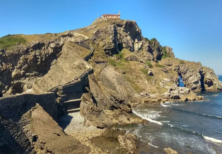 Escaleras de piedra ascienden a una ermita en la cima de un acantilado rocoso. Un lugar imprescindible que ver en Bermeo.