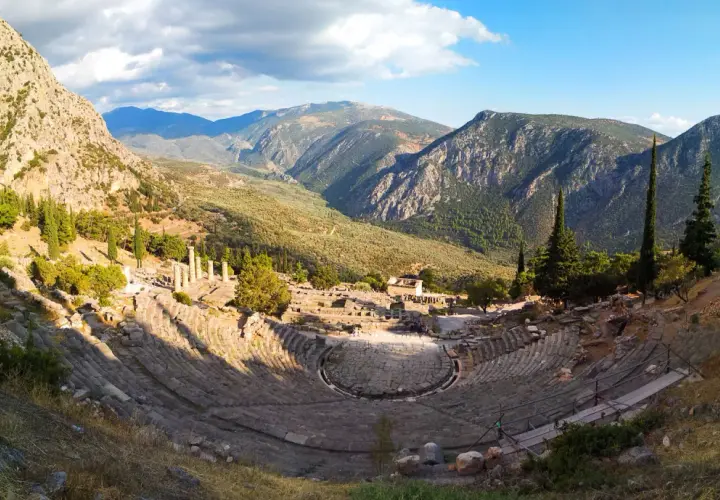 Teatro antiguo en Delfos, Grecia. Un lugar imprescindible que ver en Grecia en una semana, con vistas a montañas y ruinas.
