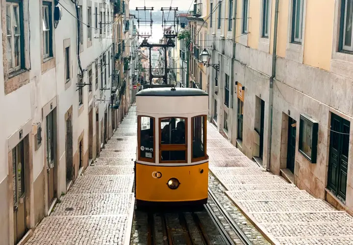 Tranvía amarillo subiendo una calle empedrada en Lisboa. ¡Imprescindible que ver en Lisboa en 4 días!