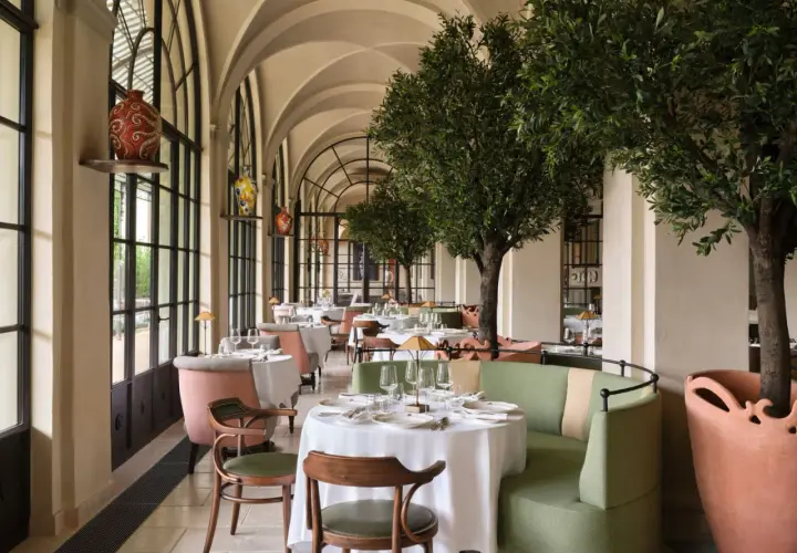Elegante comedor con mesas vestidas y árboles de olivo, ideal para saber donde comer en Florencia.