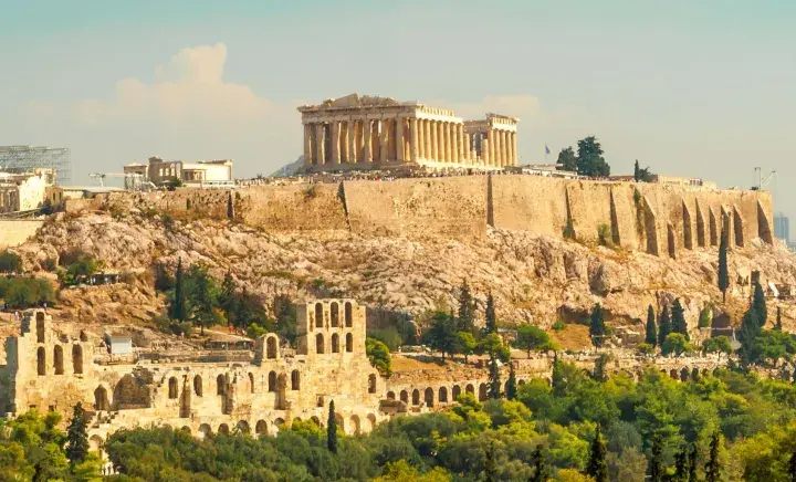 La Acrópolis de Atenas, un destino icónico para excursiones desde Atenas, se alza majestuosa sobre la ciudad.