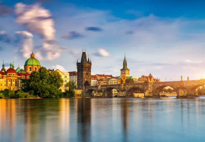 El Puente de Carlos y la arquitectura histórica de Praga reflejados en el río Moldava. Un plan perfecto para disfrutar de Praga en 3 días.