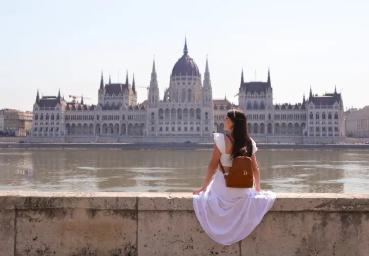 Mujer con mochila admira el Parlamento de Budapest. ¿Cuántos días para ver Budapest? ¡Un viaje inolvidable!