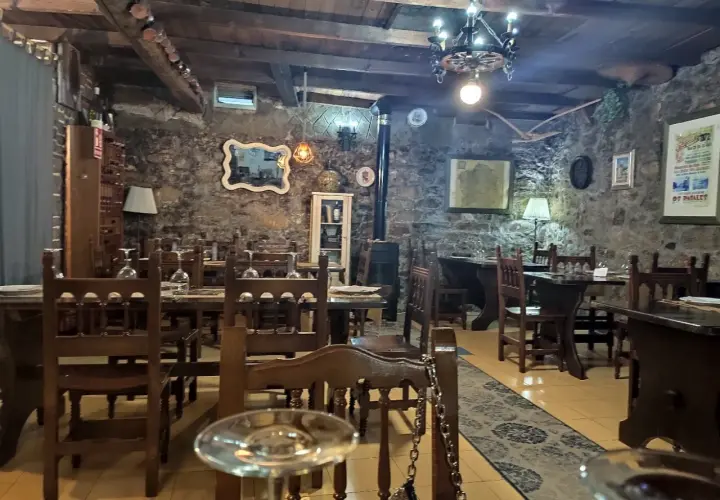 Ambiente rústico con mesas de madera y piedra, ideal para saber donde comer en Noia.