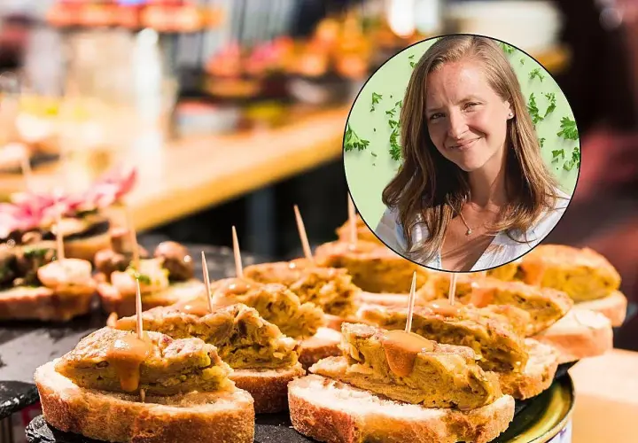 Una mujer sonríe mientras disfruta de deliciosos pintxos, una experiencia culinaria para comer en San Sebastián.