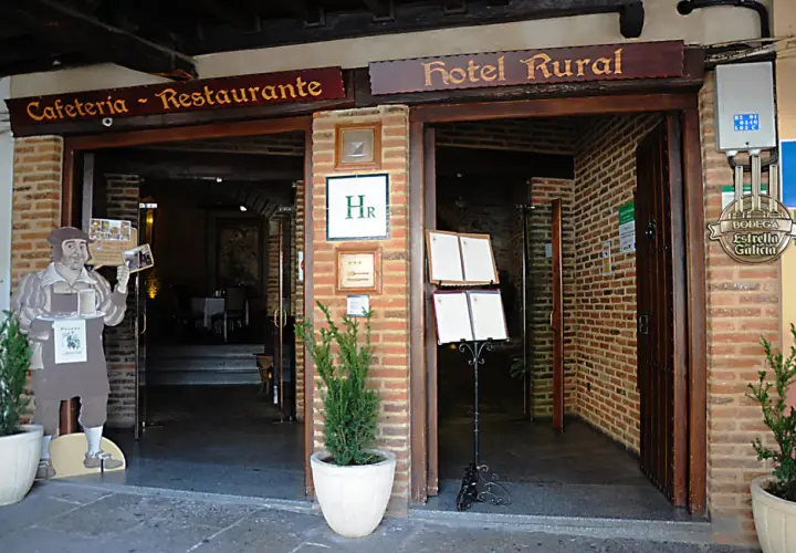 Entrada a Cafetería-Restaurante y Hotel Rural. Un cartel de un camarero invita a descubrir dónde comer en Guadalupe.