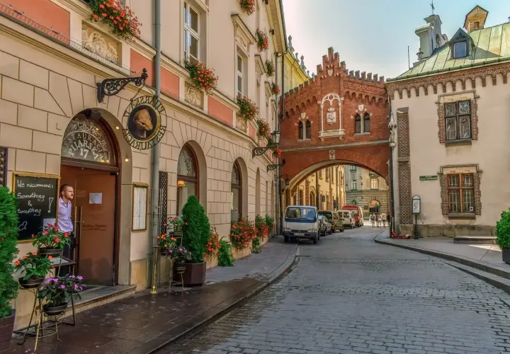 Un hombre mira desde una cafetería en Cracovia, una ciudad que ver en 3 días. Calles empedradas y arquitectura histórica.