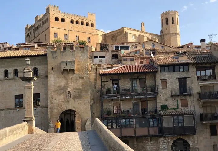 Un hombre cruza el puente hacia el castillo de Valderrobres, un lugar que ver para disfrutar de su arquitectura medieval y sus calles empedradas.