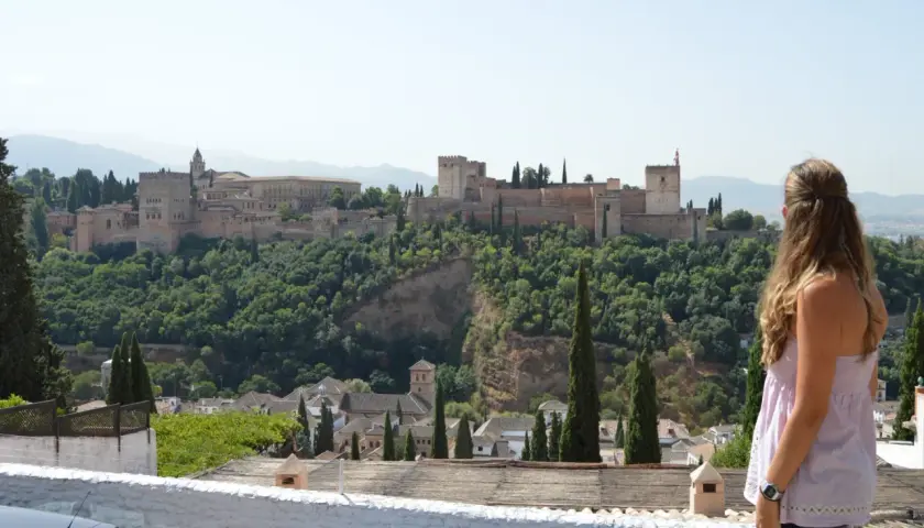 Una mujer contempla la Alhambra, un lugar imprescindible que ver en Granada en 3 días.