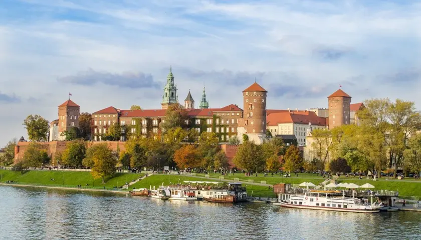 Castillo de Wawel sobre el río Vístula, ideal para excursiones en Krakow. Barcos turísticos esperan a los visitantes.