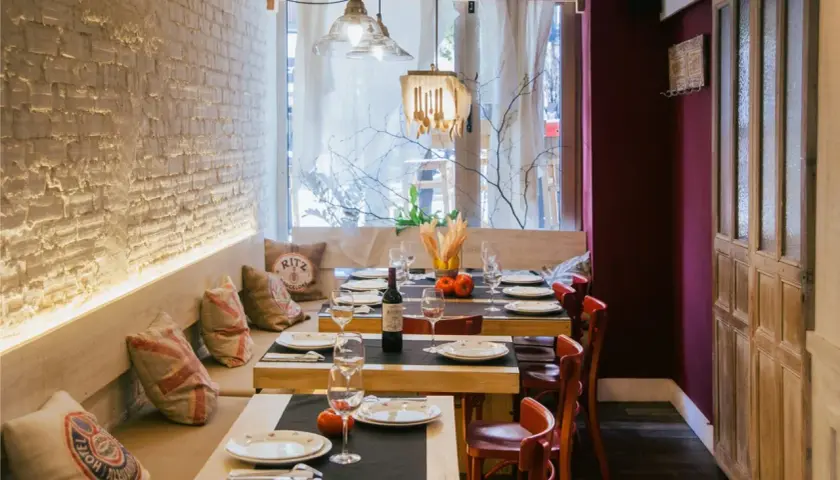 Mesas puestas en un restaurante acogedor, ideal para saber donde comer en Santander. Ambiente rústico con detalles de madera y ladrillo.
