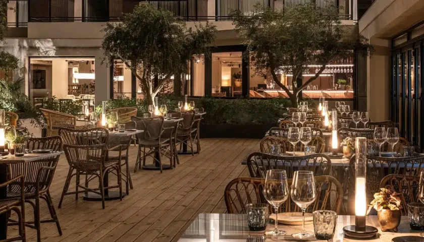 Terraza de restaurante con mesas puestas y luces tenues, ideal para saber donde comer en Benidorm.