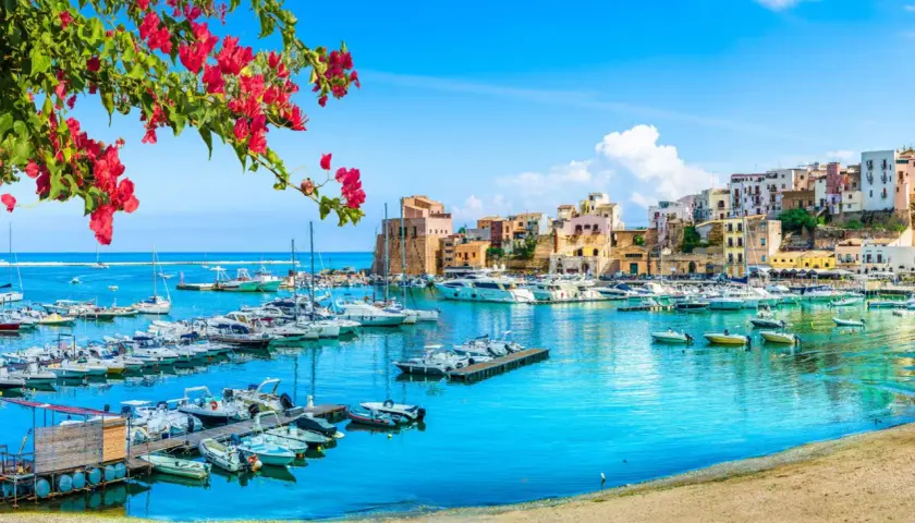 Un puerto vibrante con barcos y casas coloridas, ideal para tu plan de "Sicilia en 7 días".