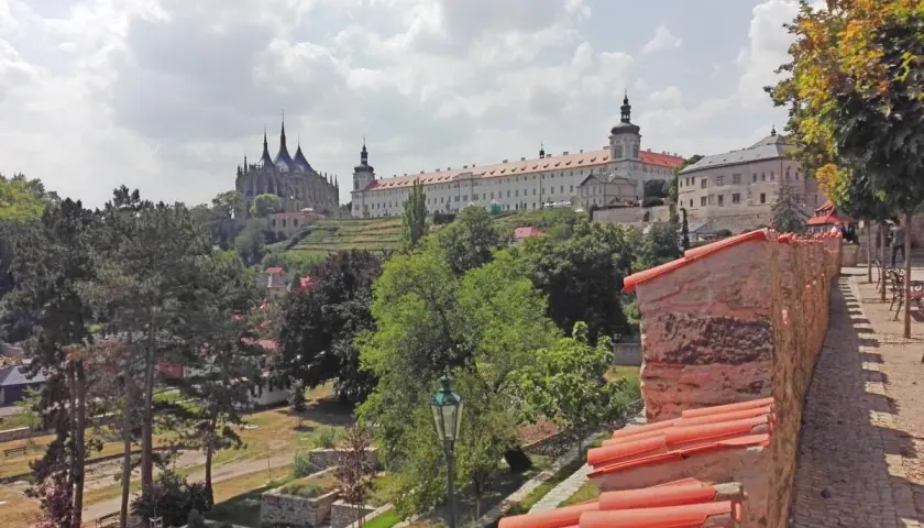 Vista panorámica de un pueblo con una iglesia gótica y un monasterio. Ideal para excursiones en Prague.