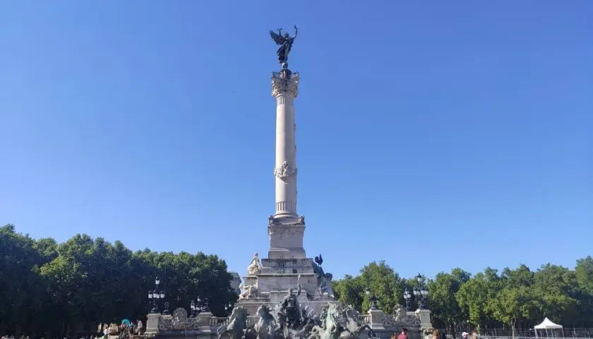 Monumento de la Gironda en Burdeos, ideal para un free tour Burdeos. Gente paseando bajo el cielo azul.