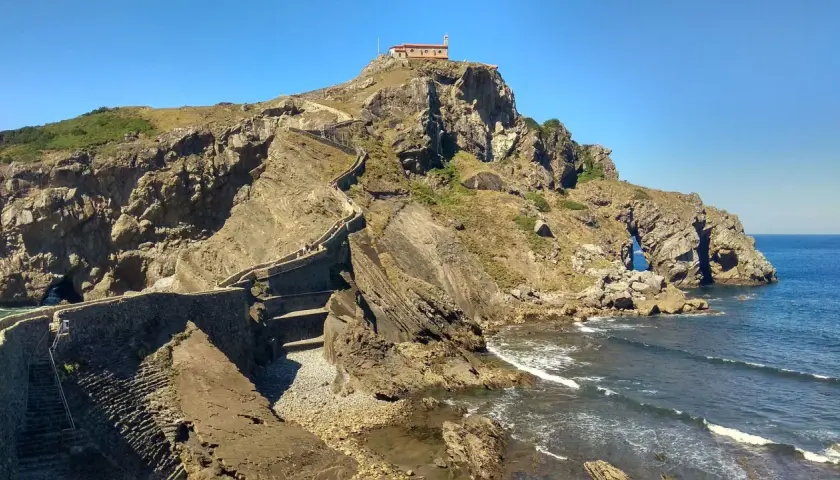Escaleras de piedra ascienden a una ermita en la cima de un acantilado rocoso. Un lugar imprescindible que ver en Bermeo.