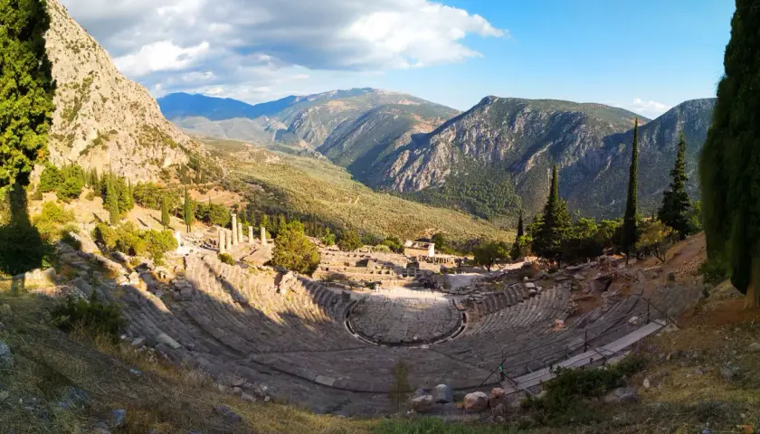 Teatro antiguo en Delfos, Grecia. Un lugar imprescindible que ver en Grecia en una semana, con vistas a montañas y ruinas.