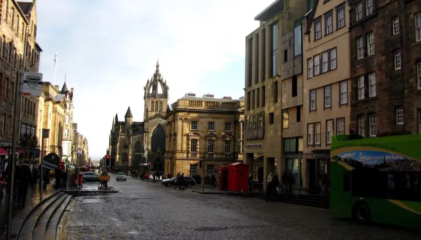 Calle adoquinada con edificios históricos y una iglesia gótica. Ideal para saber qué ver en Edimburgo en 2 días.
